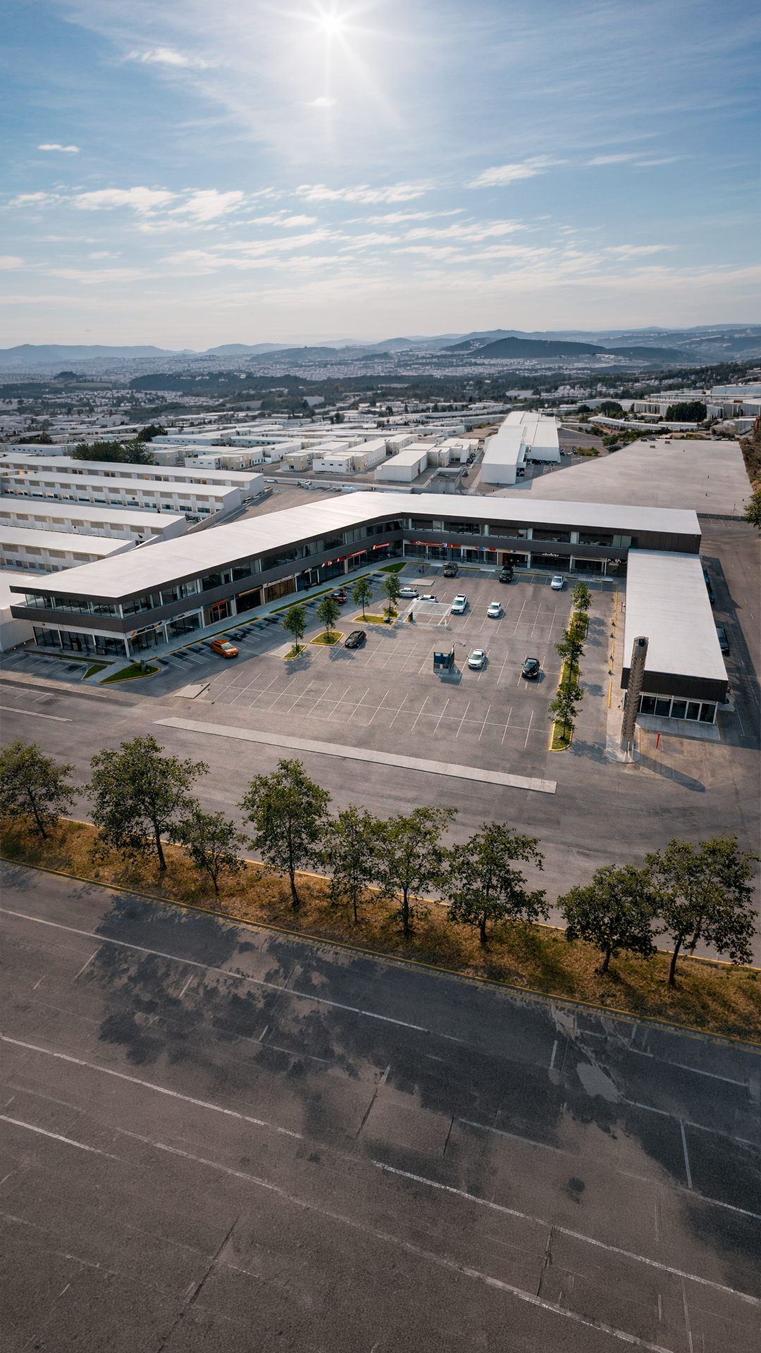 Vista exterior de Europlaza con locales comerciales en planta baja y segundo nivel, construcción comercial Fer Et Ciment León